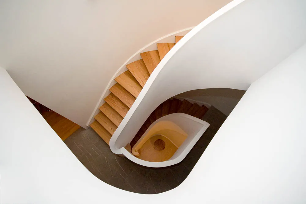 Curved white staircase with oak treads seen from above