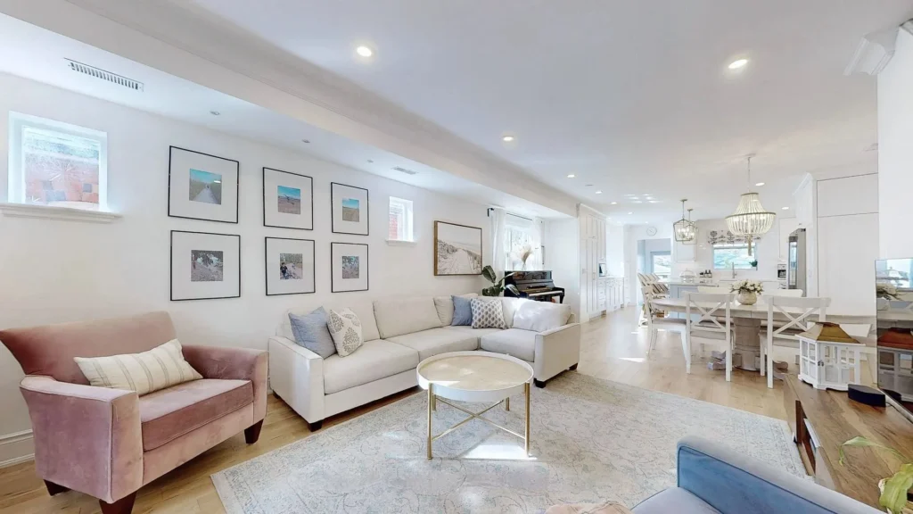 Open-concept living room with framed gallery wall and dining area beyond