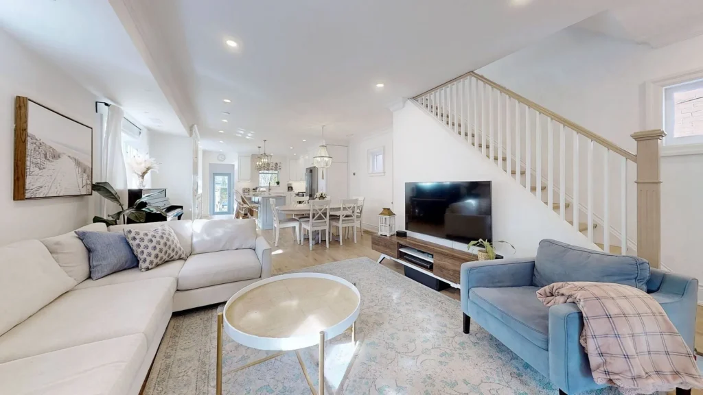 Main floor living room with open staircase and dining area beyond